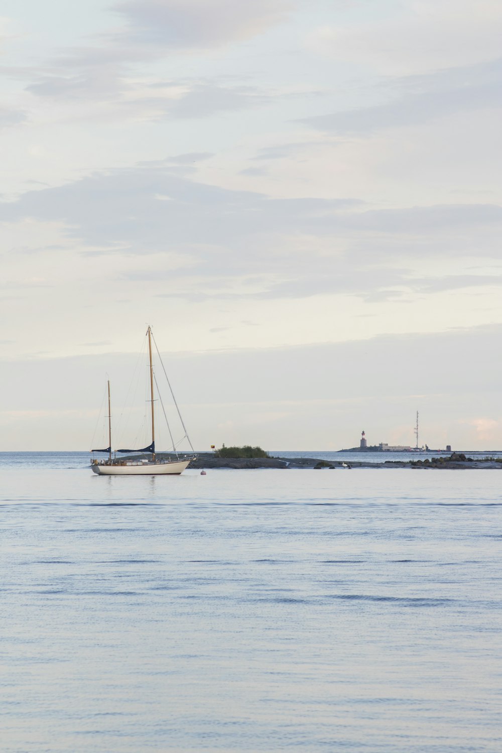 a sailboat floating in the ocean on a cloudy day