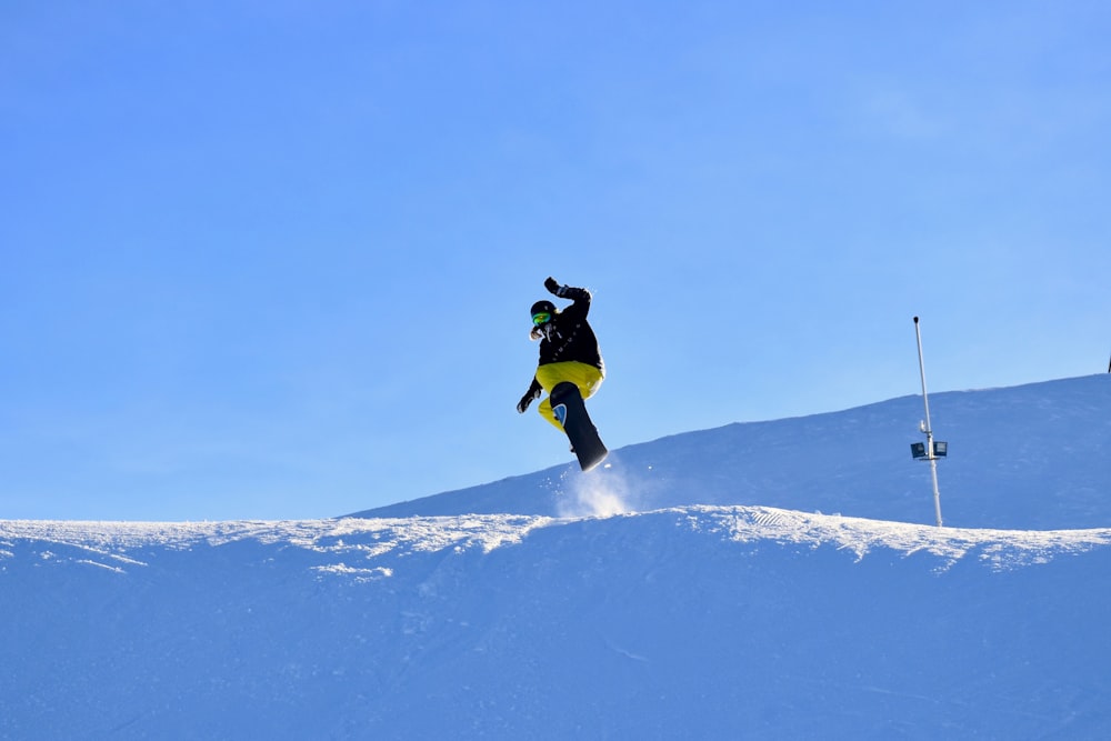 a man flying through the air while riding a snowboard