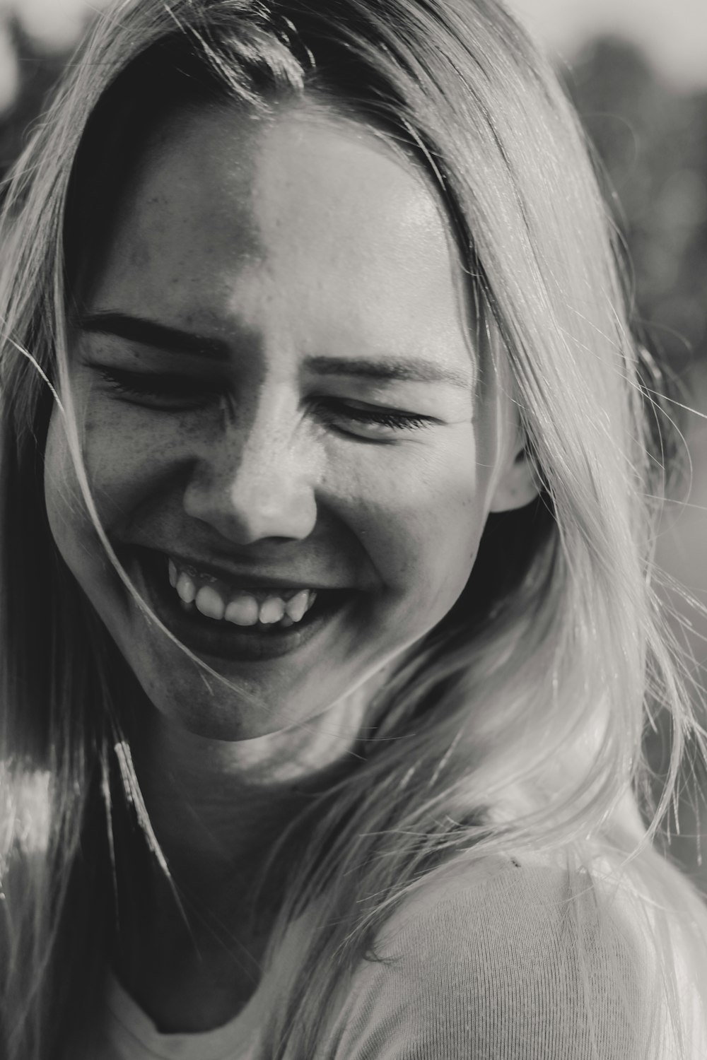 a black and white photo of a woman smiling