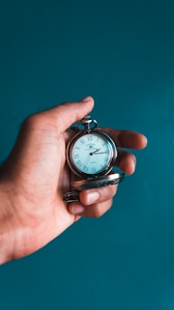 person holding pocket watch