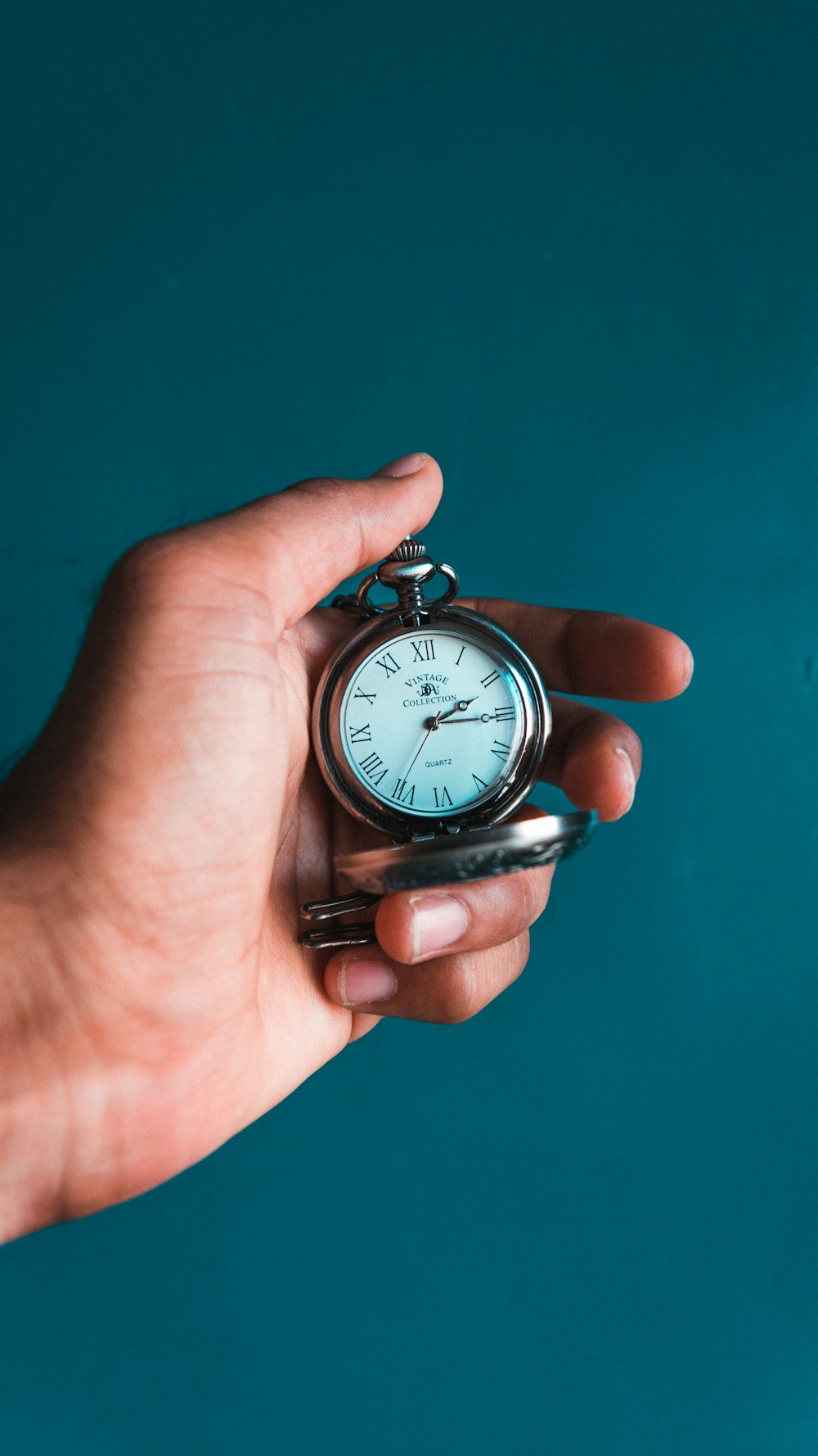 personne tenant une montre à gousset