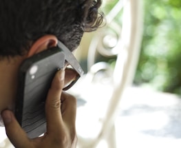 A friendly team member answering a phone call in an outdoor worksite setting.