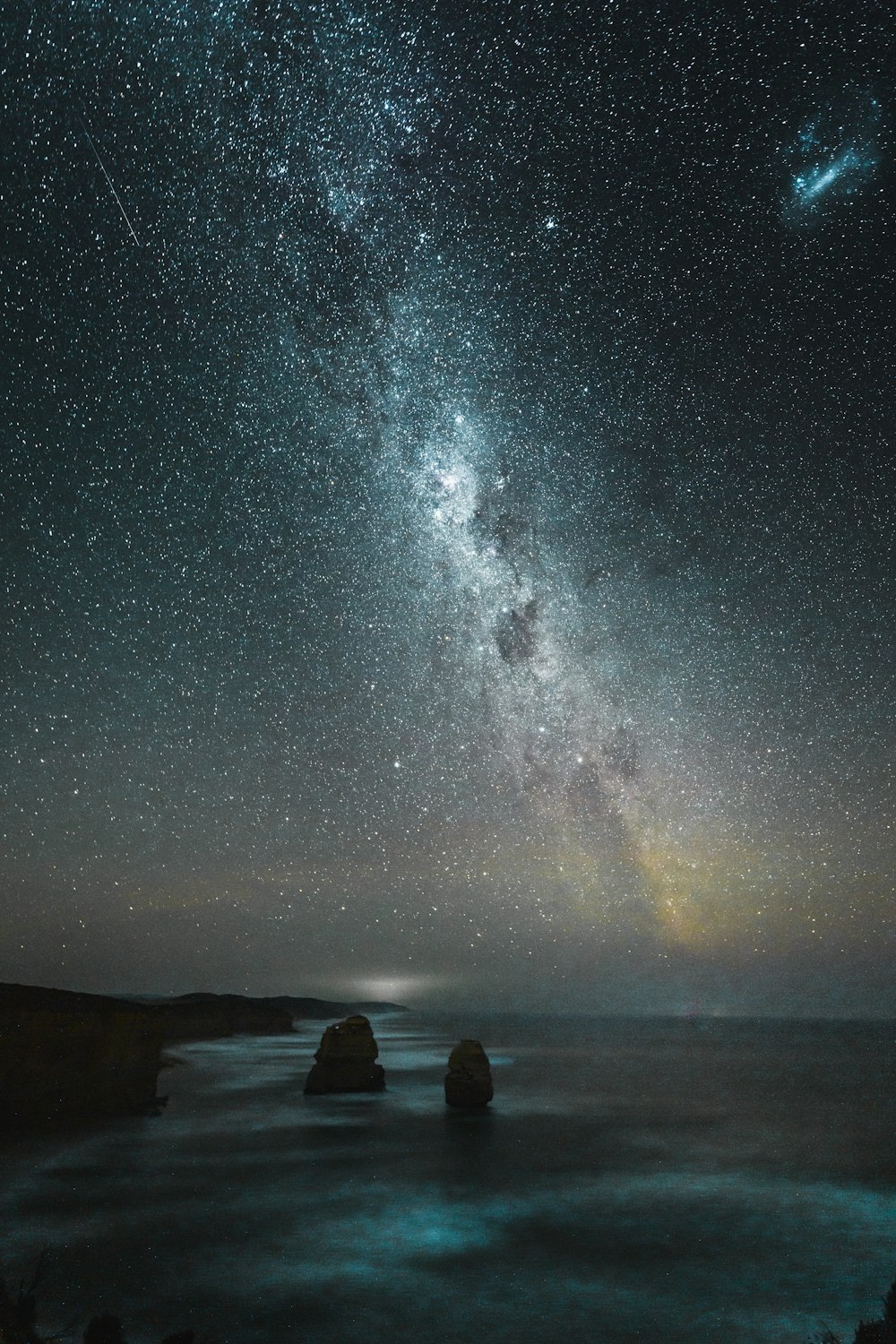 Formazione rocciosa vicino alla riva durante la notte stellata