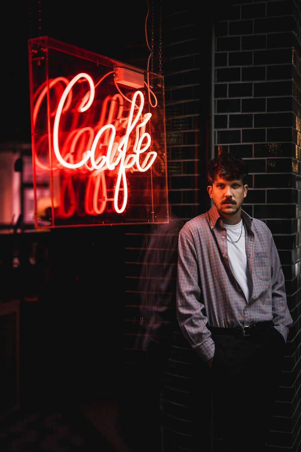 man standing beside red LED signage