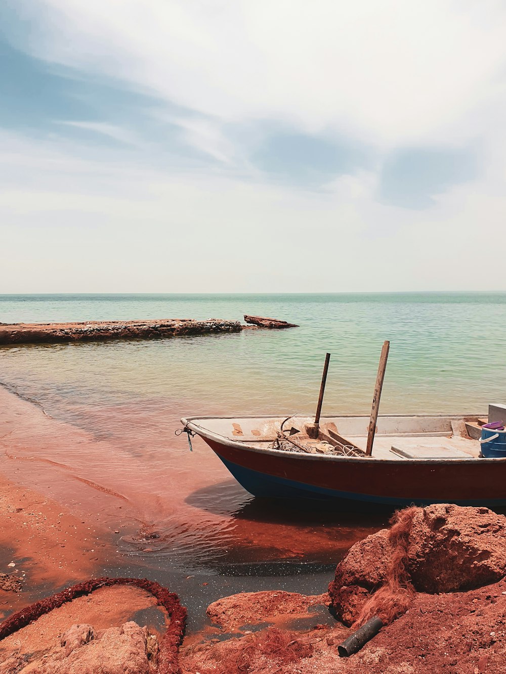 blue and white power boat beside brown rock