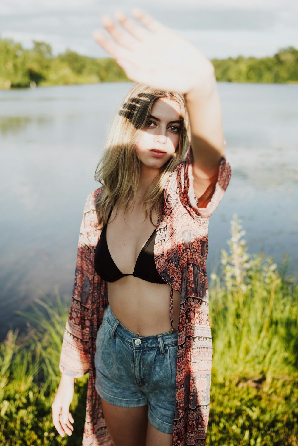 woman wearing red and brown floral top near body of water