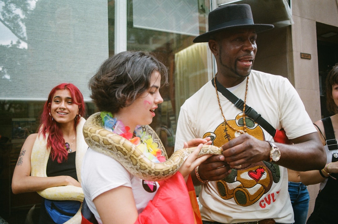 woman standing and holding snake during daytime