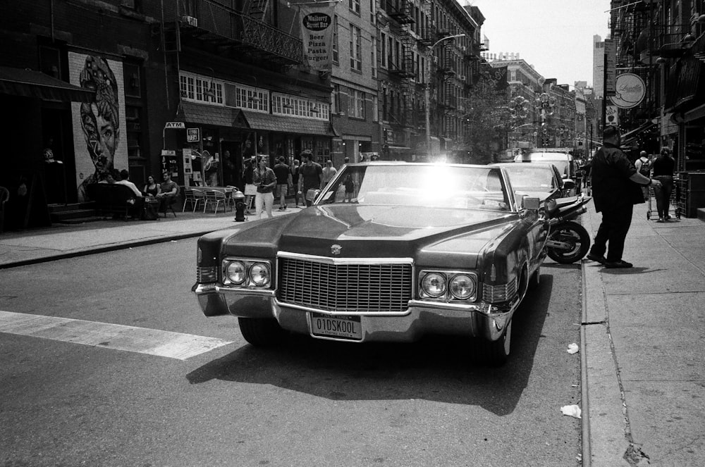 empty roadster parked on roadside in grayscale photo