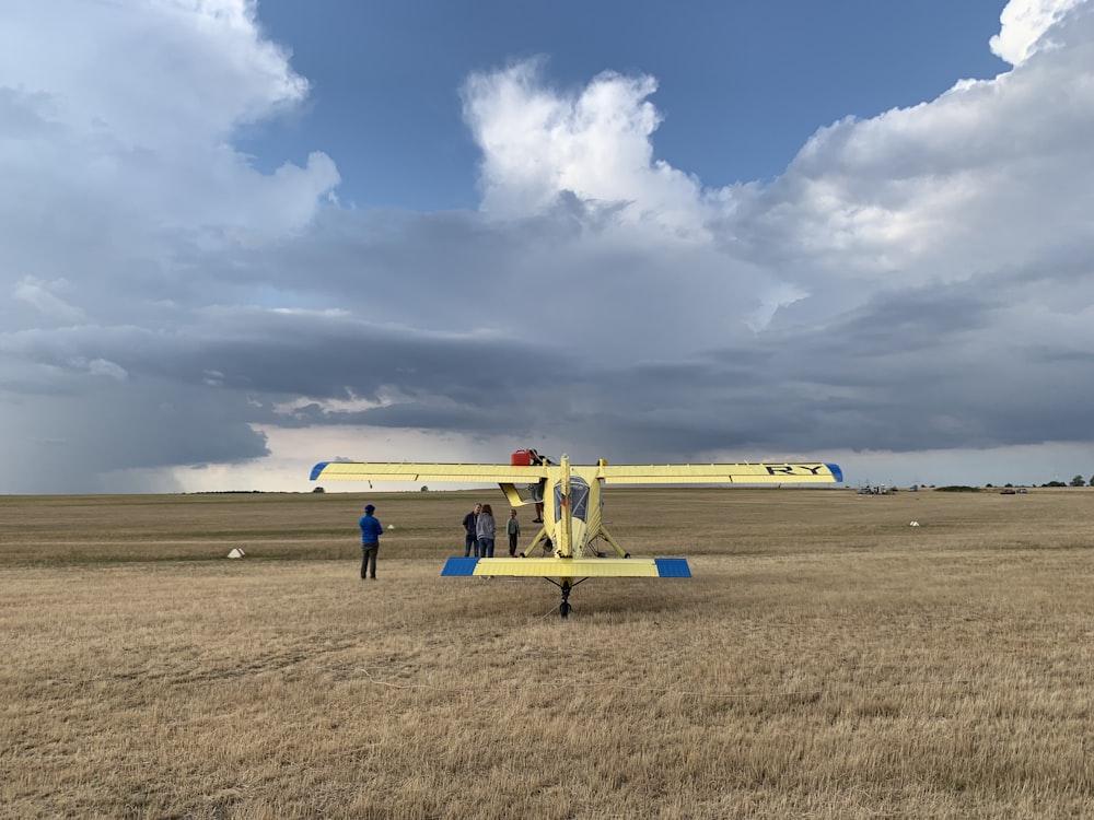 yellow and blue bi-plane outdoor during daytime