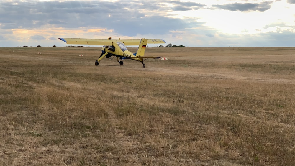 yellow plane on brown grass during daytime