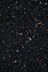 a close up of a cell phone laying on top of a pile of gravel