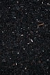 a close up of a cell phone laying on top of a pile of gravel
