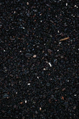 a close up of a cell phone laying on top of a pile of gravel