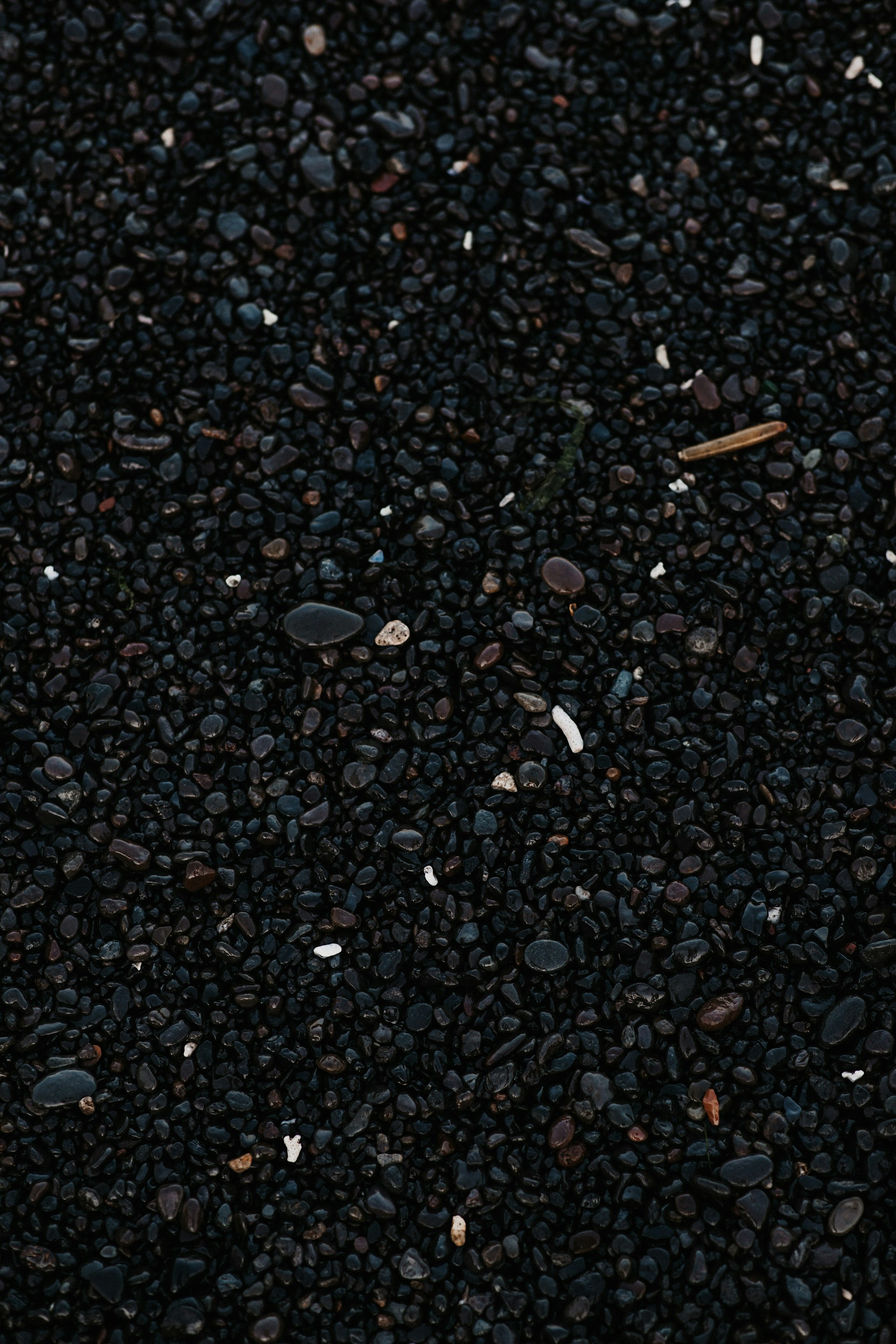 a close up of a cell phone laying on top of a pile of gravel