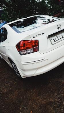 A Honda City sedan parked outside a bustling city landmark.