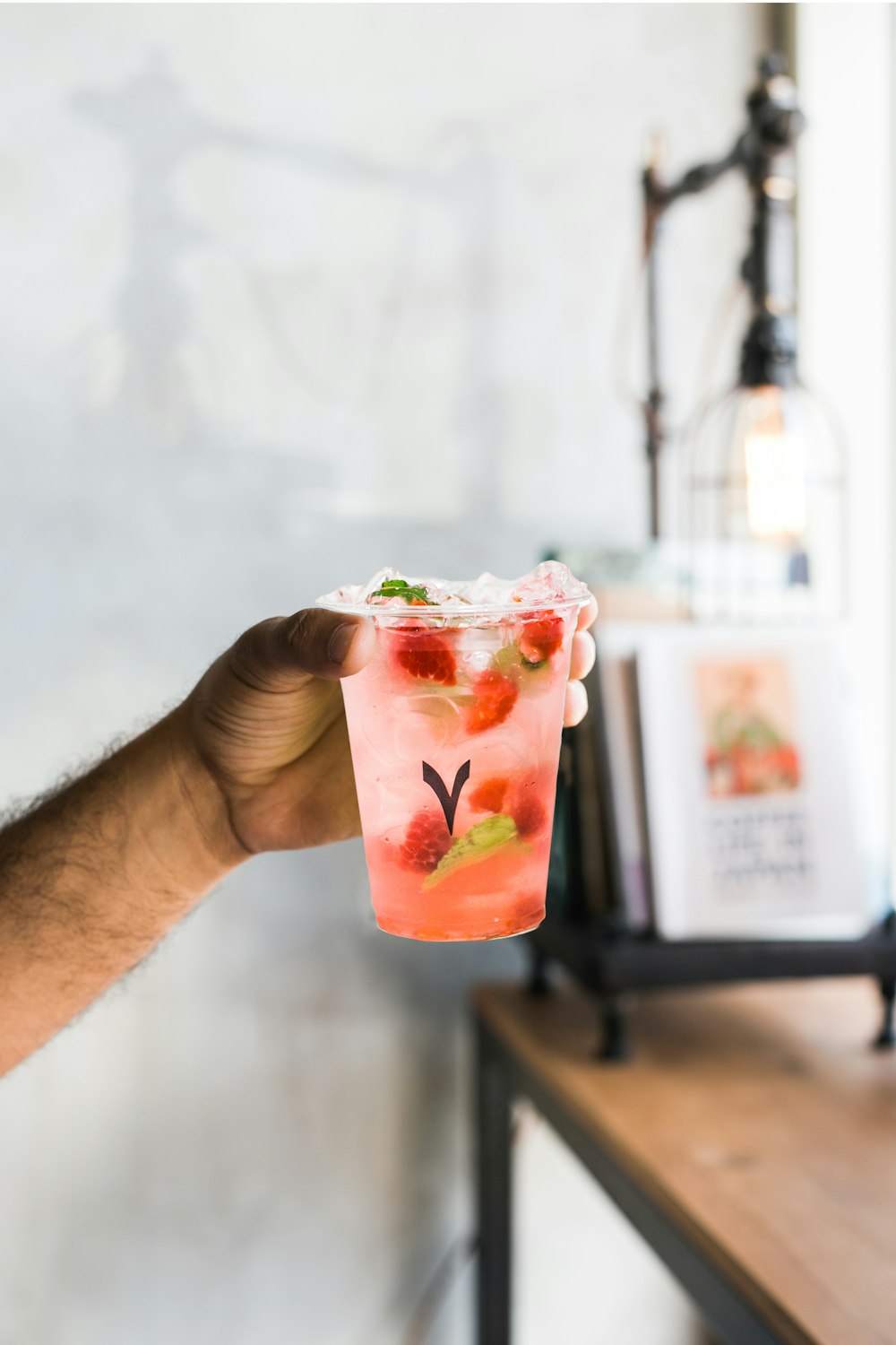 person holding cup with strawberries