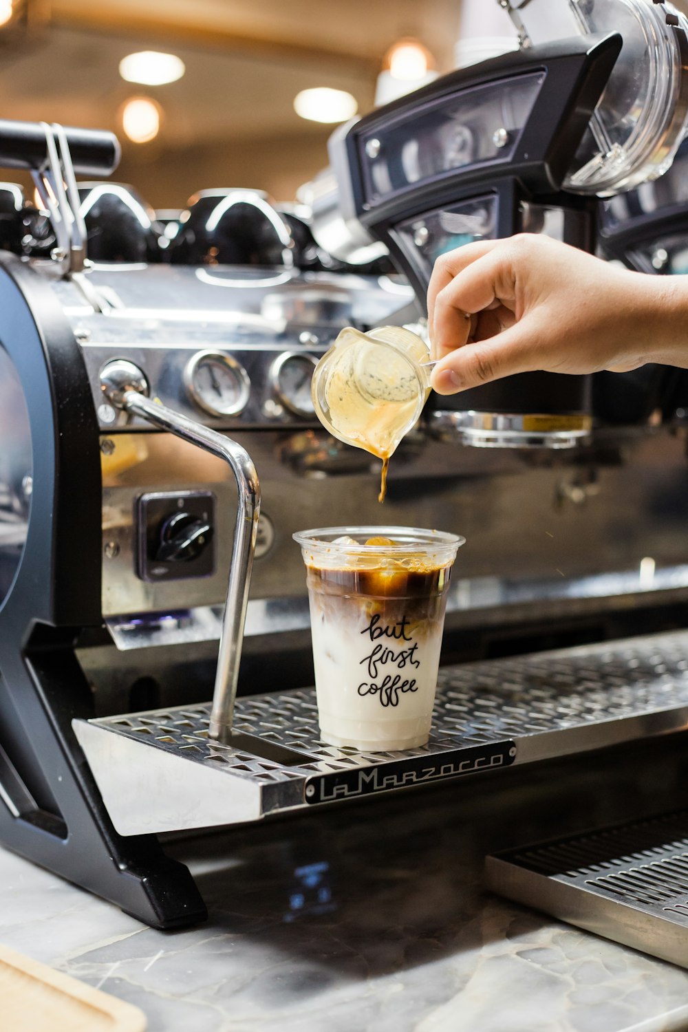 a person pours a cup of coffee from a coffee machine