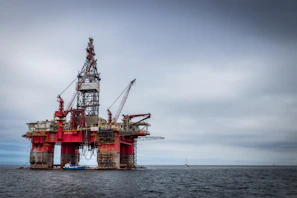 red and grey oil platform in sea