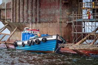 Marine engineer checking the integrity of a large fender attached to a dock.
