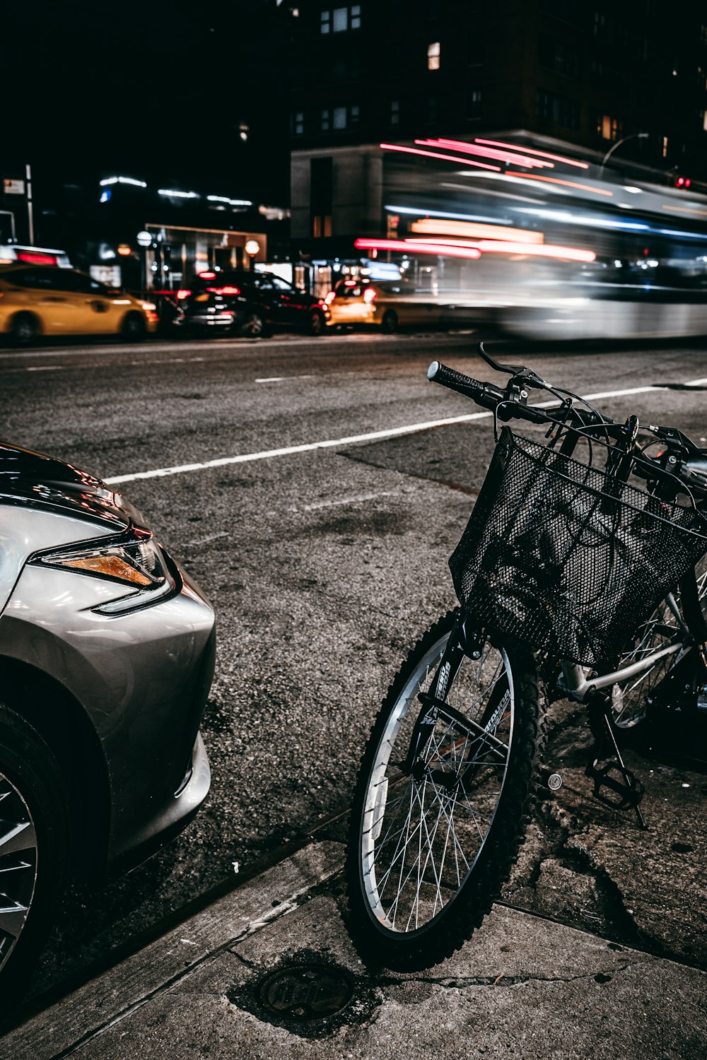 grey and black bike parked in sidewalk