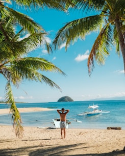 man standing near beach line