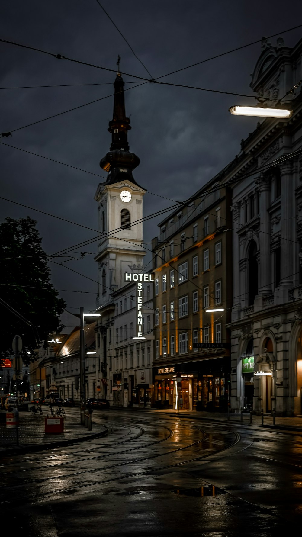 a city street at night with a clock tower in the background