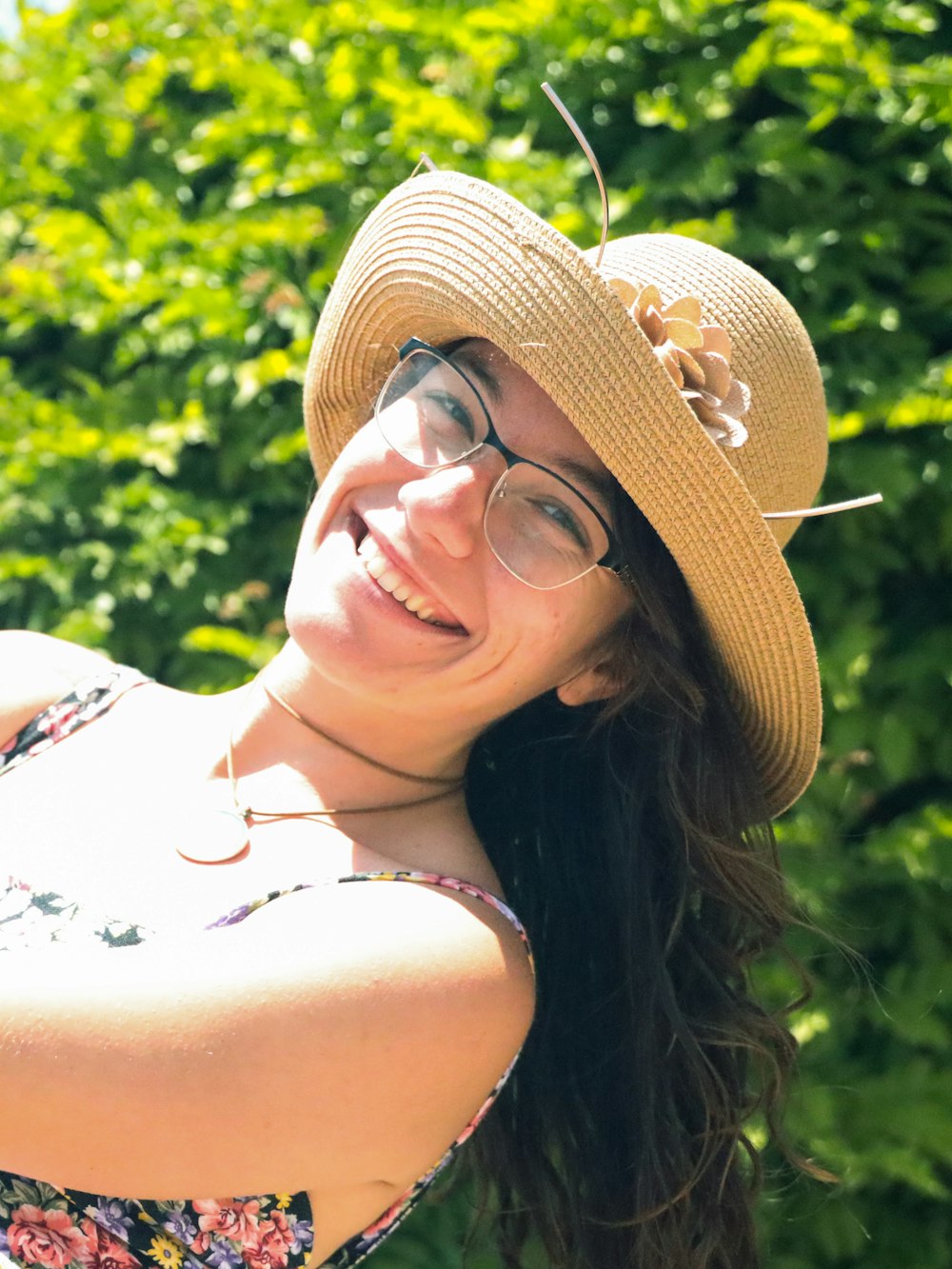 woman wearing eyeglasses and brown sunhat smiling