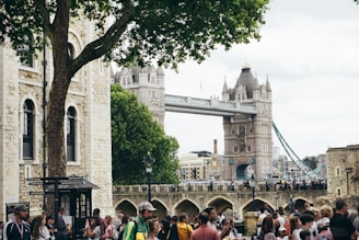 Cozy tour guide sharing stories with a small group in front of the iconic Tower Bridge at dusk.