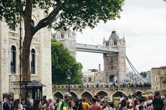 Tourists enjoying a sunny day while exploring the Tower Bridge with a private guide.