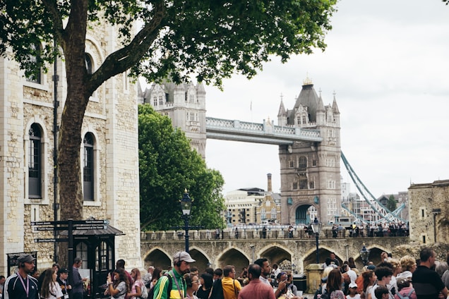 Cozy tour guide sharing stories with a small group in front of the iconic Tower Bridge at dusk.