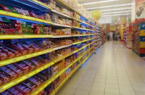 Close-up of neatly arranged packaged snacks and groceries on shelves.