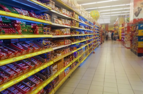 Close-up of colorful packaged grocery items neatly arranged on shelves.