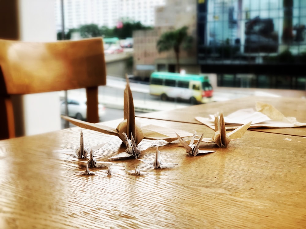 a wooden table topped with lots of paper airplanes