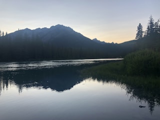 Serene landscape with muted colors and a calm lake reflecting the sky.