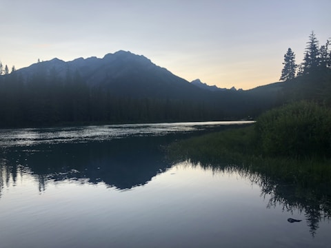 Serene landscape with muted colors and a calm lake reflecting the sky.