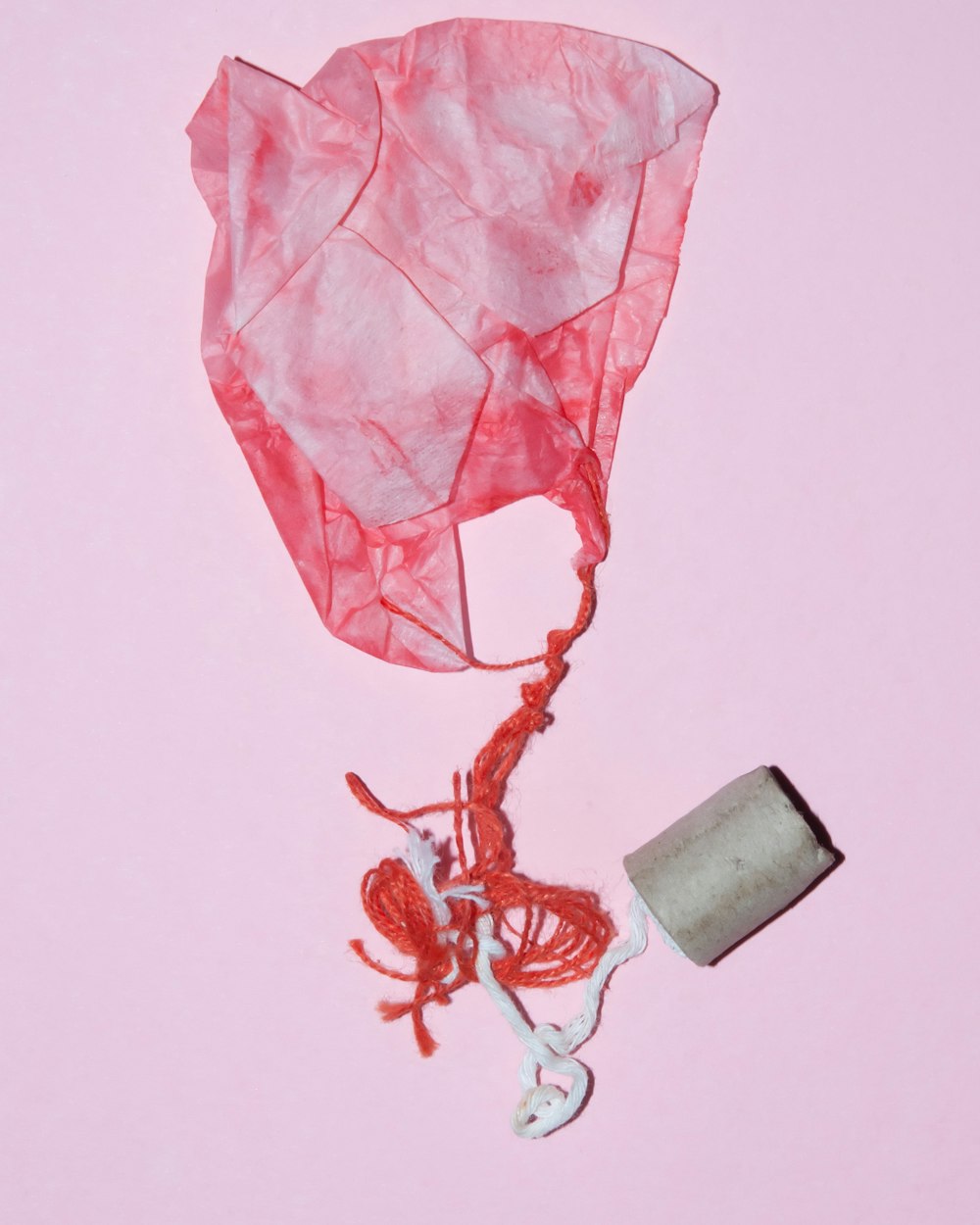 white and pink paper bag with string