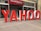 Large red and white letters spelling out 'YAHOO' are positioned outside a building labeled 'Global Business Centre.' The letters are three-dimensional and stand on the sidewalk, creating a striking visual against the building's facade.
