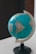 A globe displaying parts of North and South America is mounted on a stand. It is positioned on a light surface, with a focus on the Americas and some visible labels for countries like Brazil.
