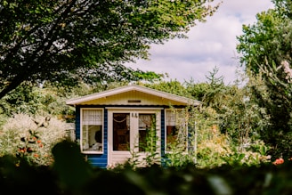 white and blue house surrounded by green trees