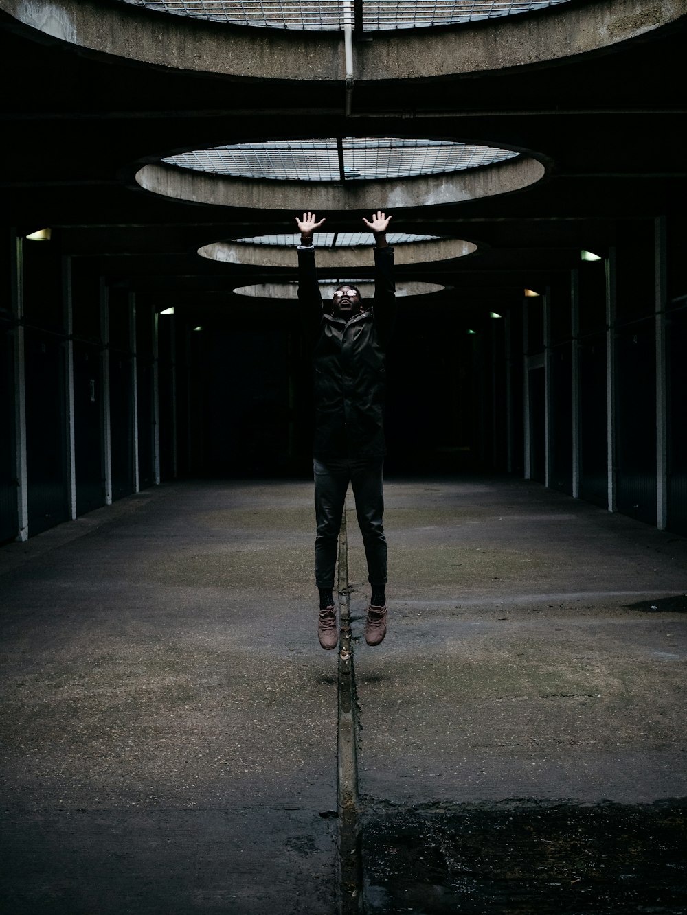 a person standing in a dark room with their hands in the air