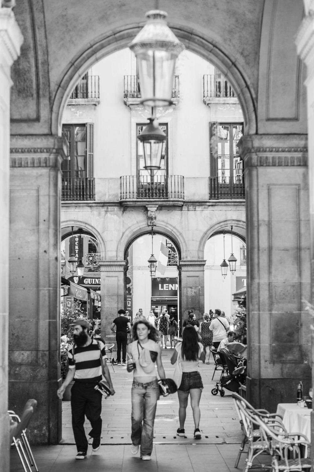 grayscale photo of people walking inside building