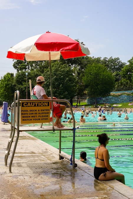 People swimming in an outdoor public pool on a sunny summer day