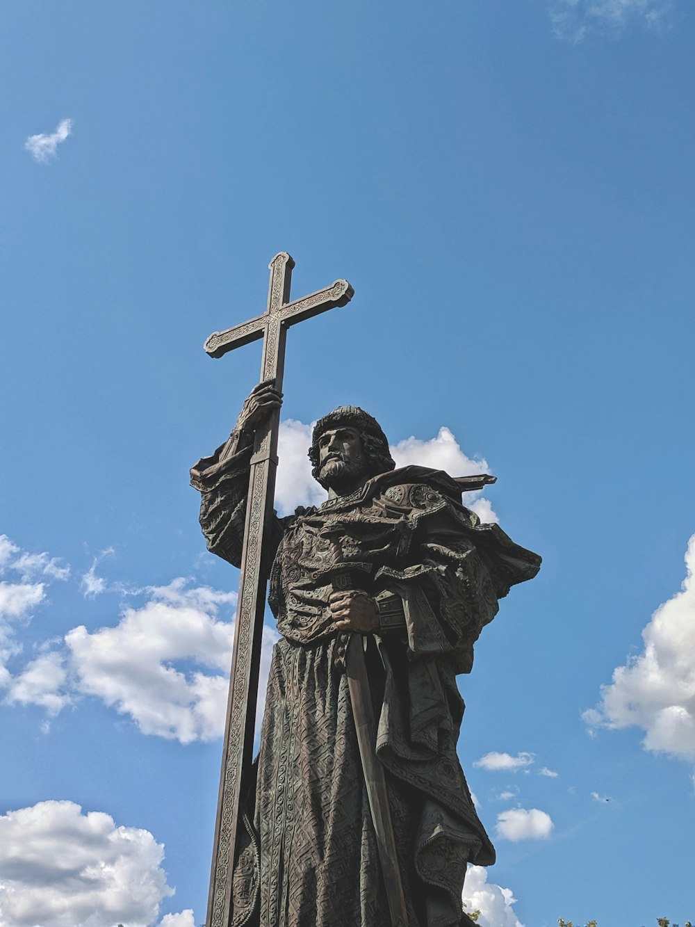 man with cross statue
