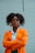woman in orange blazer standing