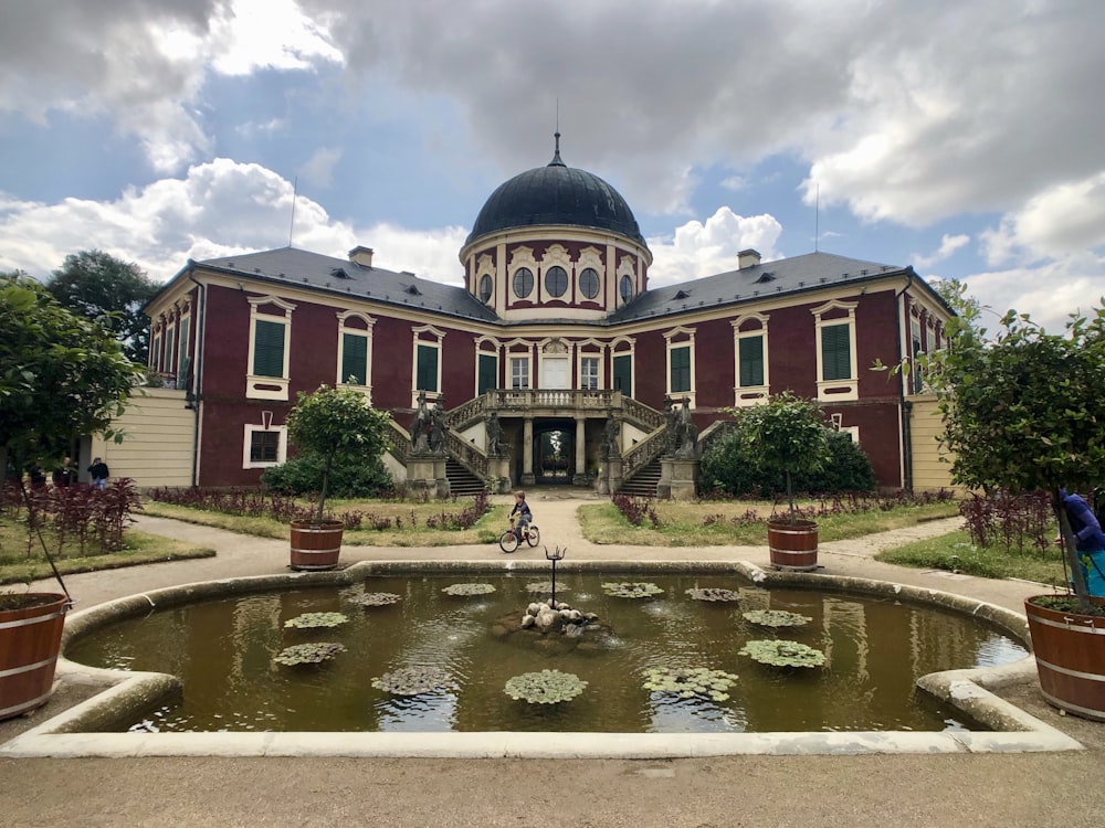 pond near maroon and brown dome building