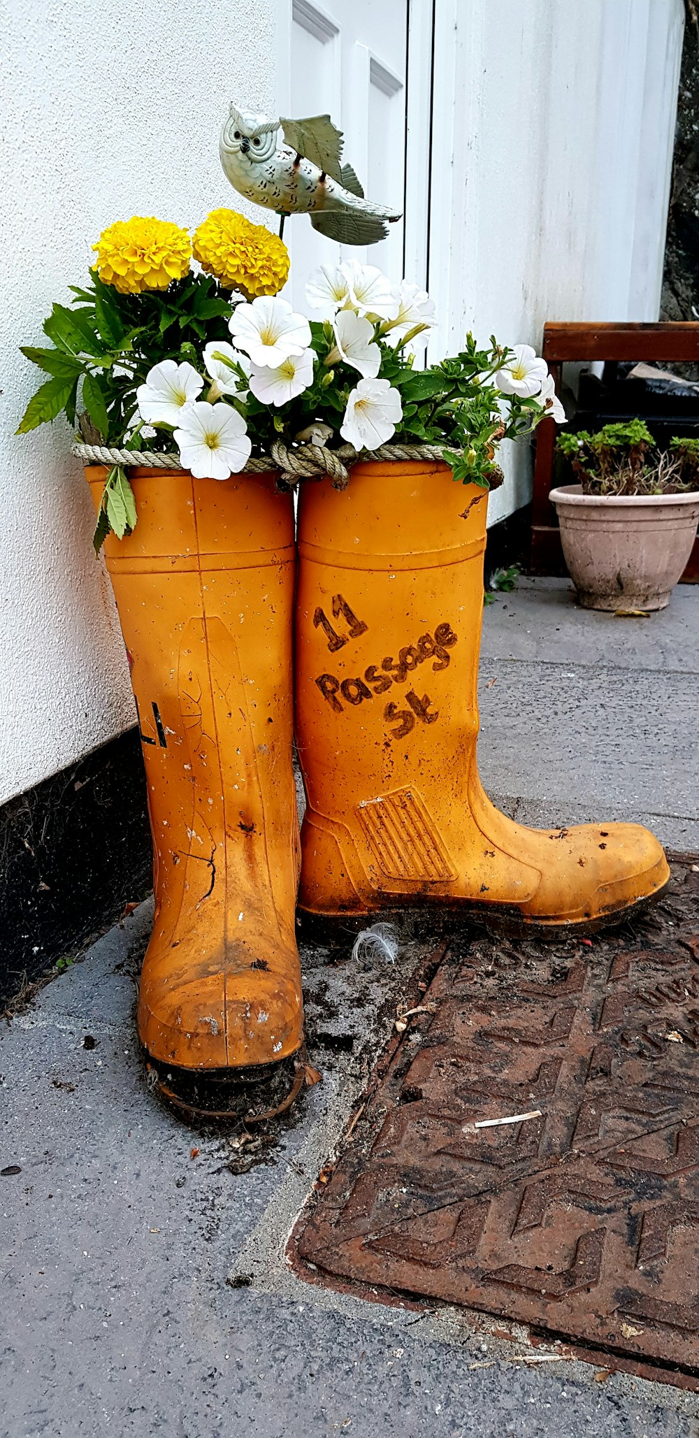 a pair of yellow rubber boots with flowers in them