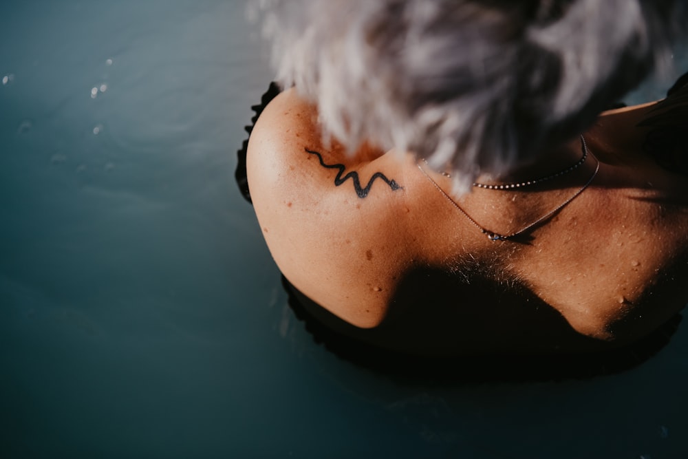 a person with a tattoo on their back in the water