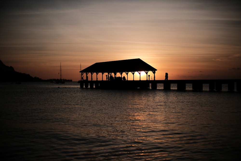 silhouette of gazebo on dock during golden hour