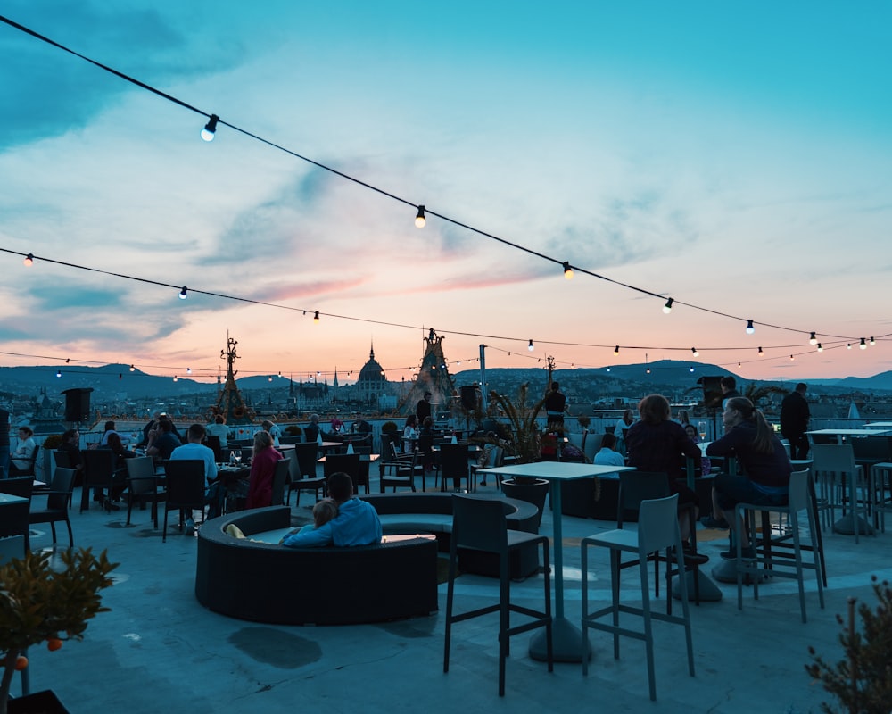 a group of people sitting at tables on top of a roof