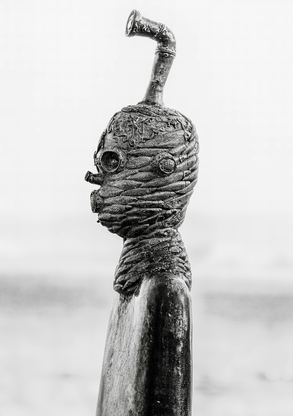 a statue of a head with a pipe sticking out of it